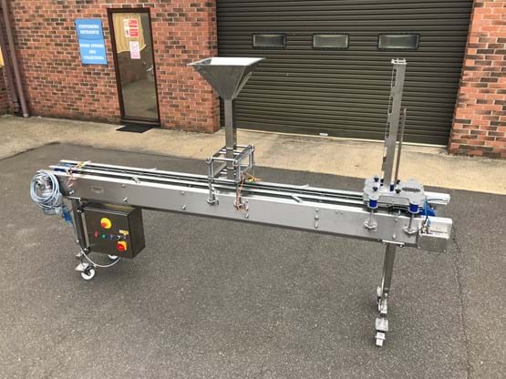 Indexing conveyor with denester & delivery chute